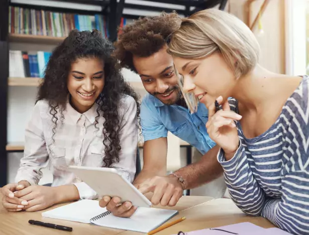 group-of-three-young-good-looking-startupers-sitting-in-light-coworking-space-talking-about-future-project-looking-through-design-examples-on-digital-tablet-friends-smiling-talking-about-work