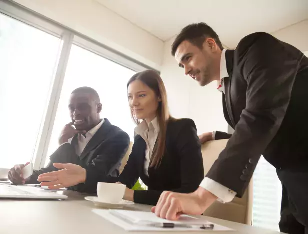 multiracial-business-partners-using-laptop-during-meeting-looki