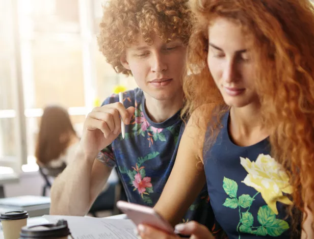 redhead-female-male-sitting-together-surrounded-with-copy-books